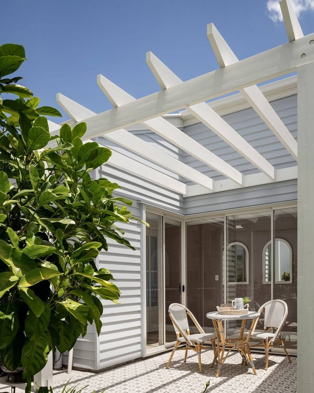 Freshly painted white weatherboard home exterior with pergola and crisp trims